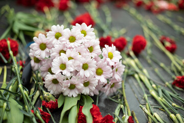 Naklejka na ściany i meble Flowers on memorial. Bouquet of flowers on gravestone.