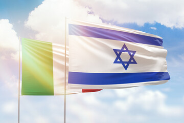Sunny blue sky and flags of israel and italy