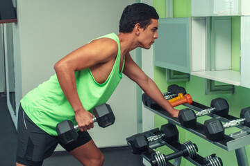 Brown man lifting weights in green shirt