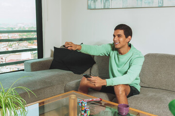 Brown man changing television channel