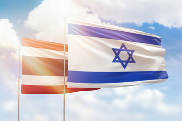Sunny blue sky and flags of israel and thailand