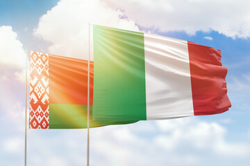 Sunny blue sky and flags of italy and belarus