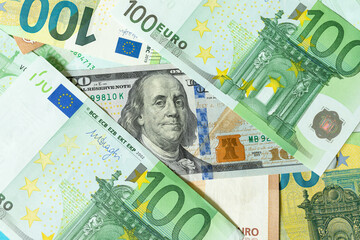 Franklin from a 100 US dollar banknote looks out between two 100 euro banknotes. The relationship between Europe and America, America's influence on the European Union concept