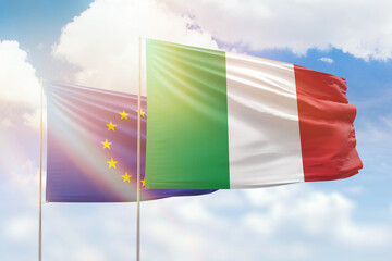 Sunny blue sky and flags of italy and european union