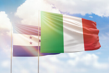 Sunny blue sky and flags of italy and honduras
