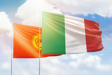 Sunny blue sky and flags of italy and kyrgyzstan