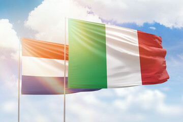 Sunny blue sky and flags of italy and netherlands
