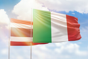 Sunny blue sky and flags of italy and thailand