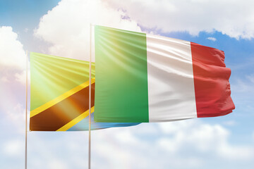 Sunny blue sky and flags of italy and tanzania