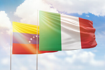 Sunny blue sky and flags of italy and venezuela
