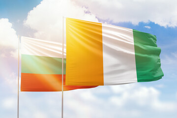Sunny blue sky and flags of ivory coast and bulgaria