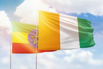 Sunny blue sky and flags of ivory coast and ethiopia