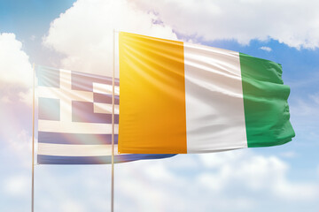 Sunny blue sky and flags of ivory coast and greece