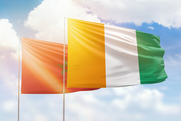 Sunny blue sky and flags of ivory coast and morocco
