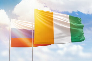 Sunny blue sky and flags of ivory coast and russia