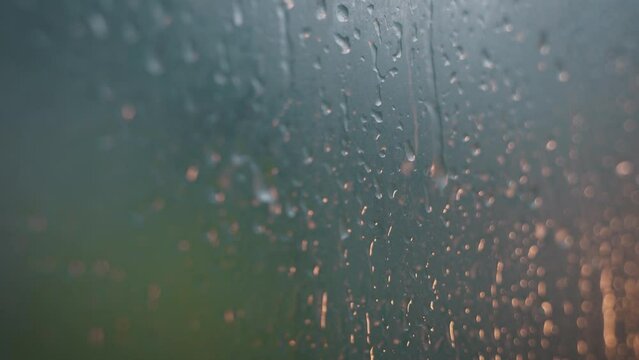 Drops of water on the glass transparent window with colored lights