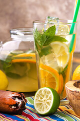 Refreshing lemonade with lemon and mint in a glass and decanter.