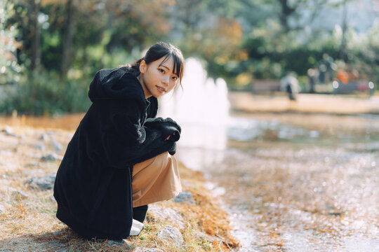 愛知県名古屋市の庭園を散策する若い女性 Young woman strolling through a garden in Nagoya, Aichi, Japan.