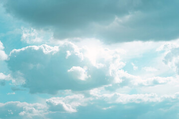 Fototapeta premium White clouds and sun rays in a blue sky.Beautiful heavenly wallpaper in blue tones. Heaven background.