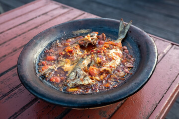 processed chili sauce made from tomatoes and chilies cooked with fresh fish on a clay plate, a typical food from Indonesia, Bontang, East Kalimantan, in Indonesian this food is called 