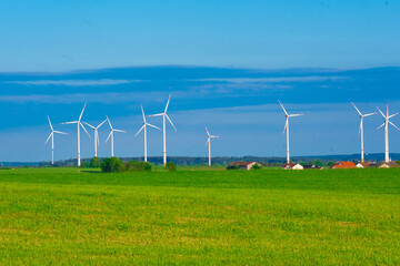 Windmill set.Wind generator and home in green field.Windmills on blue sky background.renewable energy. Environmentally friendly energy source.Natural energy.