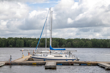 Fototapeta premium Sailboats tied up at their slips in a marina, daytime, cloudy, nobody