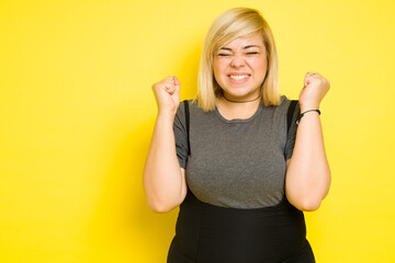 Fat woman celebrating and looking excited about something with her eyes closed and some copy space