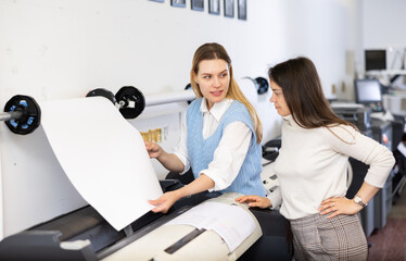 Obraz premium Team of professionals works on printing equipment