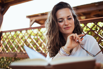 pensive modern woman in white shirt reading book