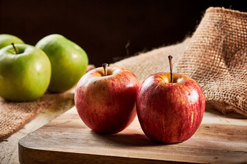 manzana roja y verde  en un fondo rustico de madera con espacio para copy