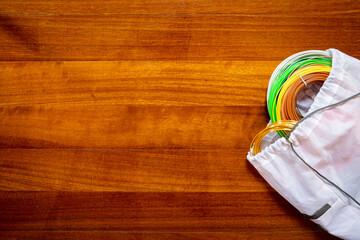 3D printing filament reels for 3d printers in a white bag isolated on wooden background
