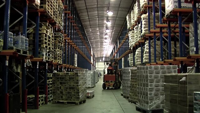 Fork Lift Driver lifting Pallets in Warehouse, Warehouse Worker driving Forklift with Pallets.