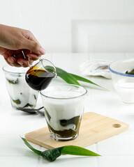 Pour Liquid Palm Sugar to the Glass with Green Grass Jelly Drink or Cingcau Hijau.