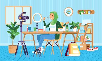 Female muslim hijab beauty blogger making review for cosmetics and recording video for her blog. Young woman talking about make up on vlog channel in room