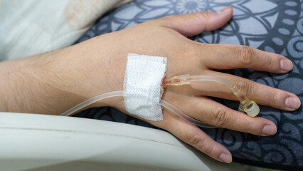 Infusion tube attached to the hand. Infusion plaster on hand with isolated focus.