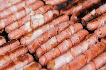 Sausages wrapped with bacon Roasted fat smoked and grilled over a bbq grill on the street food