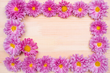 木のテーブルの上の紫の菊の花のフレーム