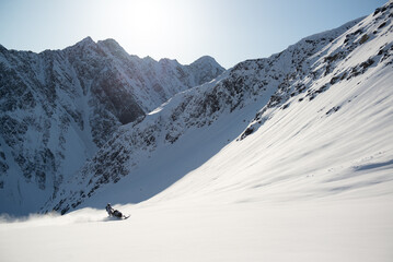Fototapeta na wymiar Snowmachine rider in Alaska backcountry