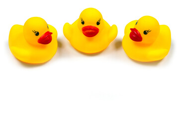 Ducklings on a white background. Three toy rubber ducklings close-up.