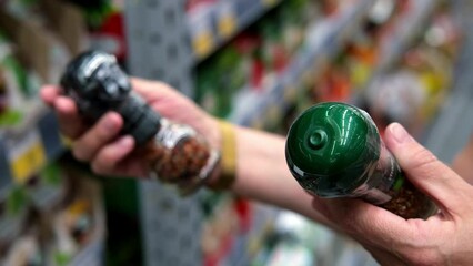 Female hands chooses spices and reads labels in supermarket close-up