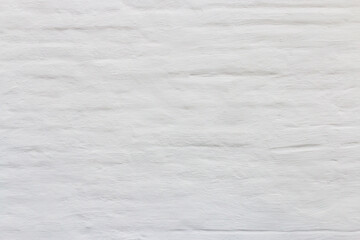 Fototapeta premium Horizontal brickwork, cement plaster, painted white. The texture of the stone wall for the background. Wallpaper.