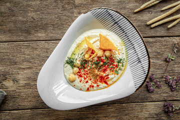 Portion of appetizing hummus spread sauce on wooden background