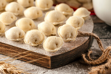 Semi finished pelmeni dumplings on wooden board
