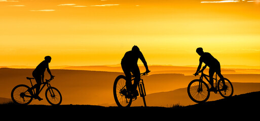 Fototapeta na wymiar Silhouette of a mountain biker enjoying downhill during the sunset. Mountain bike concept. Mountain bike race - silhouette cyclist on background.