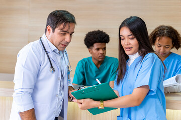 Team of diversity doctor and nurse is discussing and brainstorming on patient medical record after...