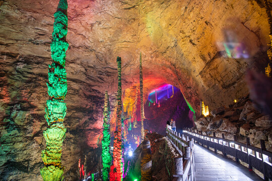 Horizontal image of the passage through Huanglong limestone cave with stalactites and stalagmites with colorful lighting, Zhangjiajie, Hunan, China, copy space for text