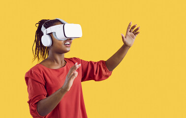 Studio shot of black woman experiencing virtual reality. Happy female Afro American gamer wearing...