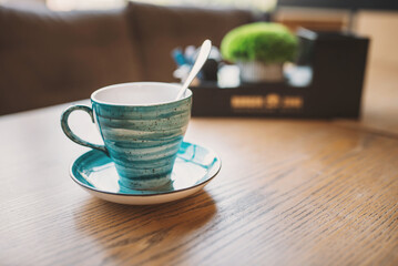 Blue vintage coffee cup on wooden table in a cafe