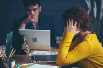 Stressed businesspeople, Frustrated and upset in business pressure and overworked at office. Adult Asian man and woman working on laptop, feeling tire and headache. Stressed and Frustrated concept.