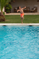 person in the pool. Blond boy with sunglasses diving into the pool